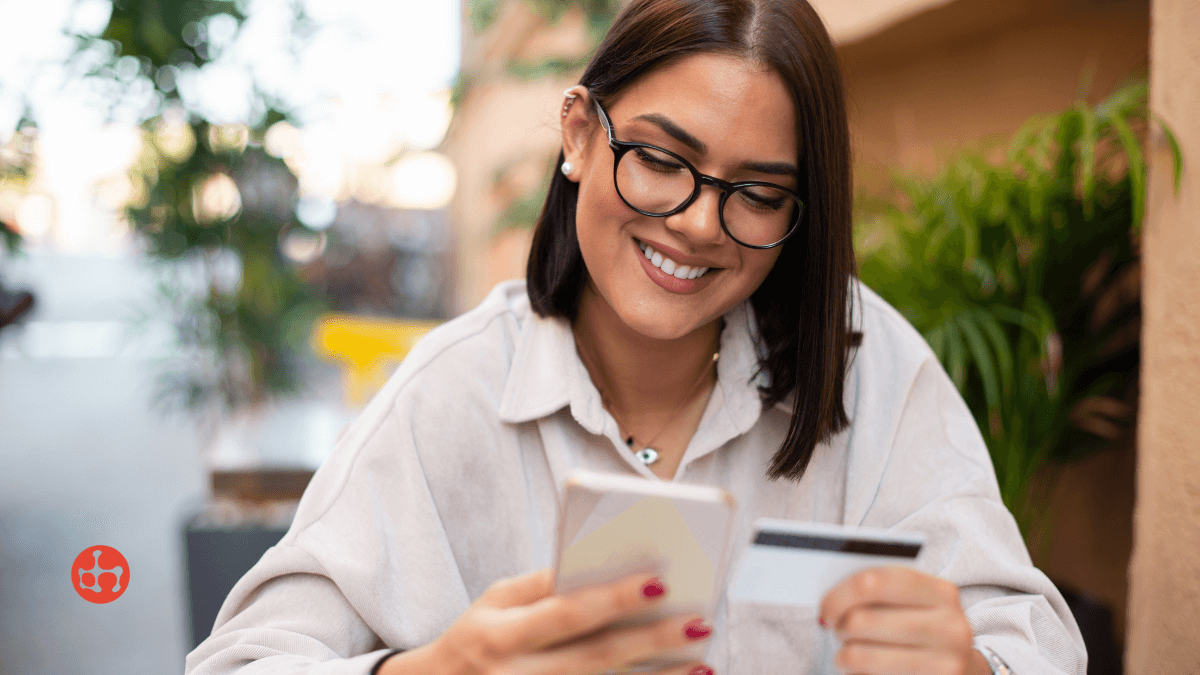 A woman booking online while holding her bank card